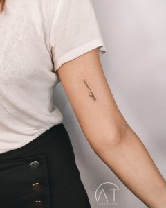 napis na przedramieniu delikatny modny tatuaż damski