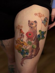 Kolorowy tatuaż pupila z kwiatami – realistyczny tatuaż zwierzęcia