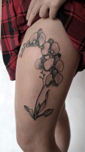 damski tatuaż roślinny na udzie 