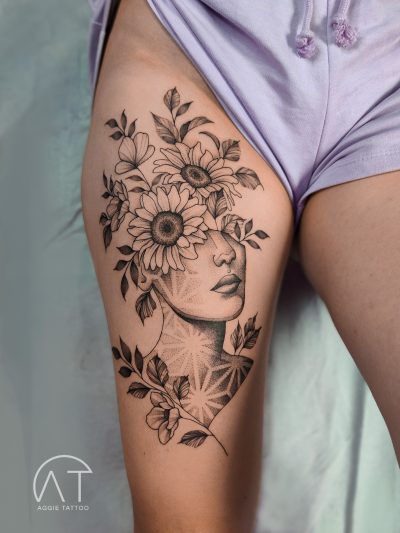 damski tatuaż na udzie - kwiaty, słoneczniki, duży motyw