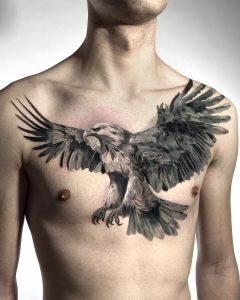 Tatuaż szeroko rozpostartego orła na klatce piersiowej, demonstrujący dynamiczne i żywe tatuaże zwierzęce jako trend na 2024 rok