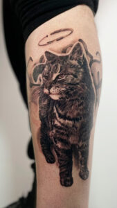 Duży realistyczny tatuaż kota z aureolą – artystyczny portret pupila