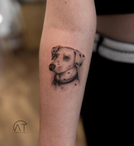 Realistyczny tatuaż psa na przedramieniu – portret pupila w czerni i szarości