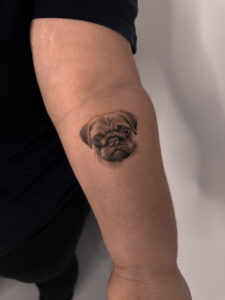 Mały tatuaż psa rasy mops na ręce – subtelny portret pupila