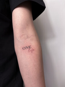 Delikatny tatuaż z napisem w stylu tiny tattoo – inspiracja 9