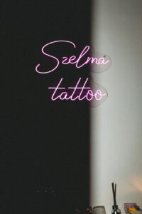 Neon z napisem Szelma Tattoo we wnętrzu studia tatuażu