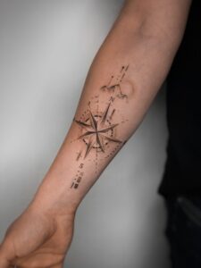 Tatuaż konceptualny z różą kompasową i geometrycznymi liniami na wewnętrznej stronie przedramienia